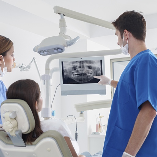 Dentist and patient looking at digital x-rays
