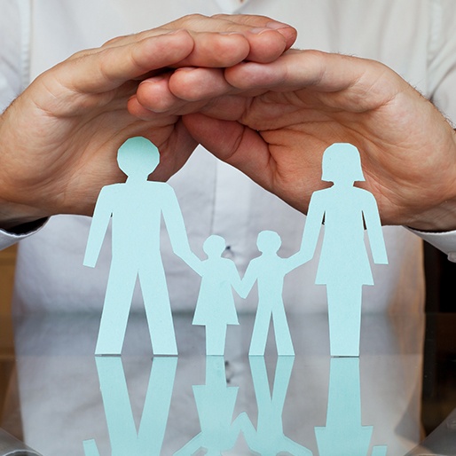 Hands protecting paper cut out family